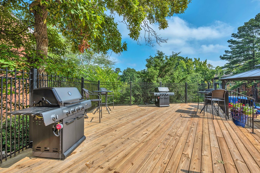 a backyard with a grill and a deck with a picnic table